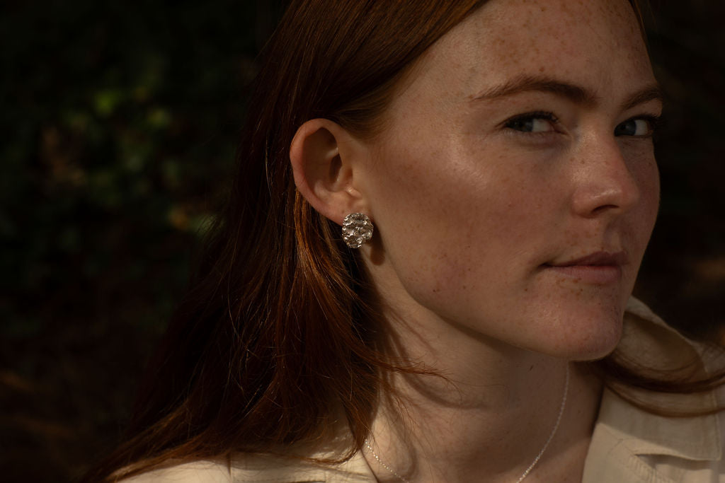 Close-up of a person with earrings and a blurred background