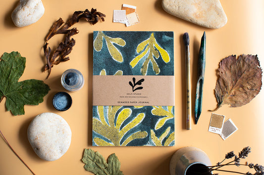 Seaweed journal with a green kelp design on an artist's table