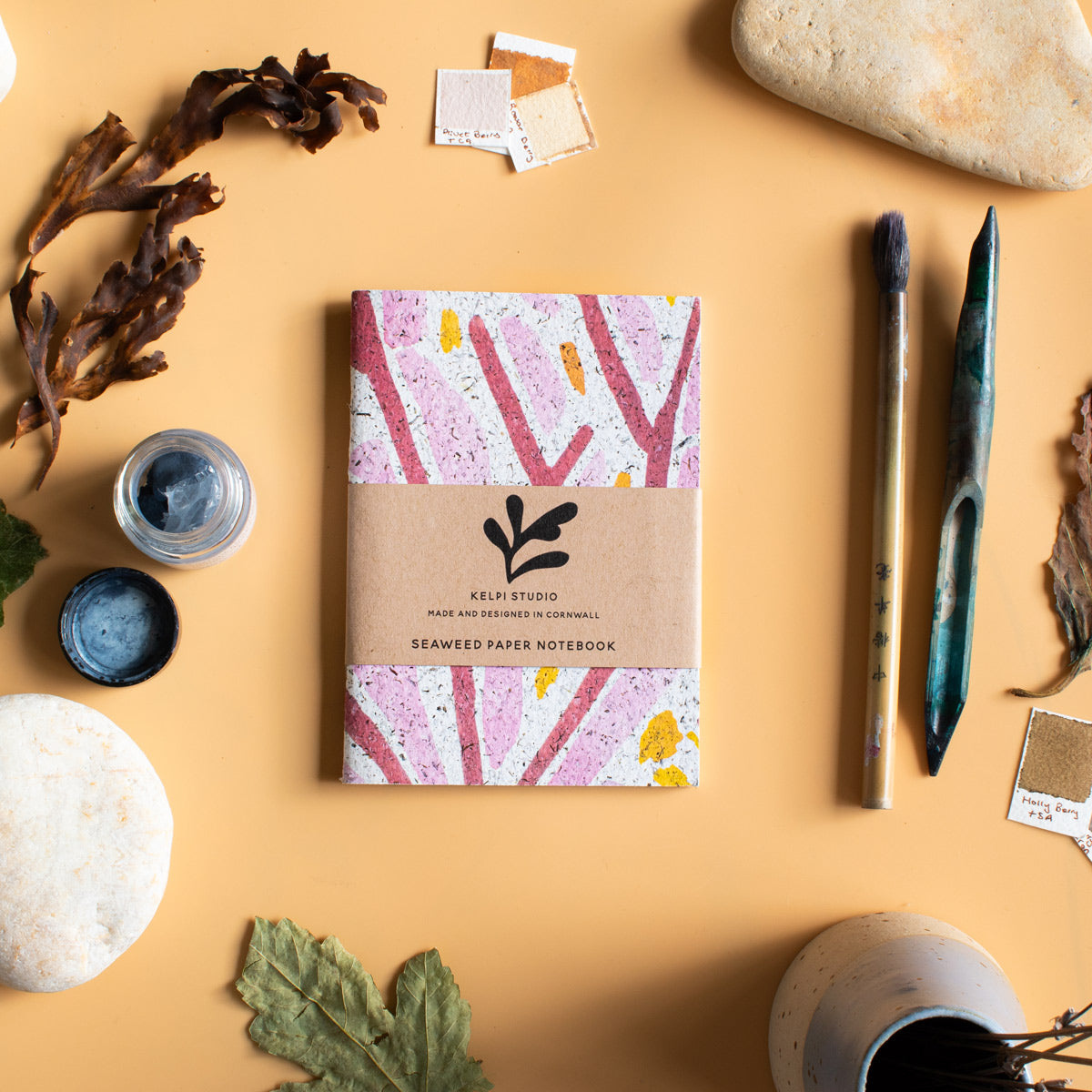 Seaweed notebook with a pink seaweed design on an artist's table