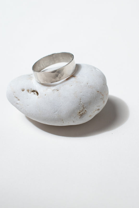 Silver ring on white pebble