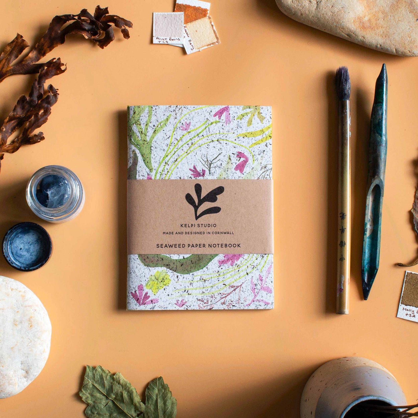 Seaweed notebook with a delicate seaweed design on an artist's table