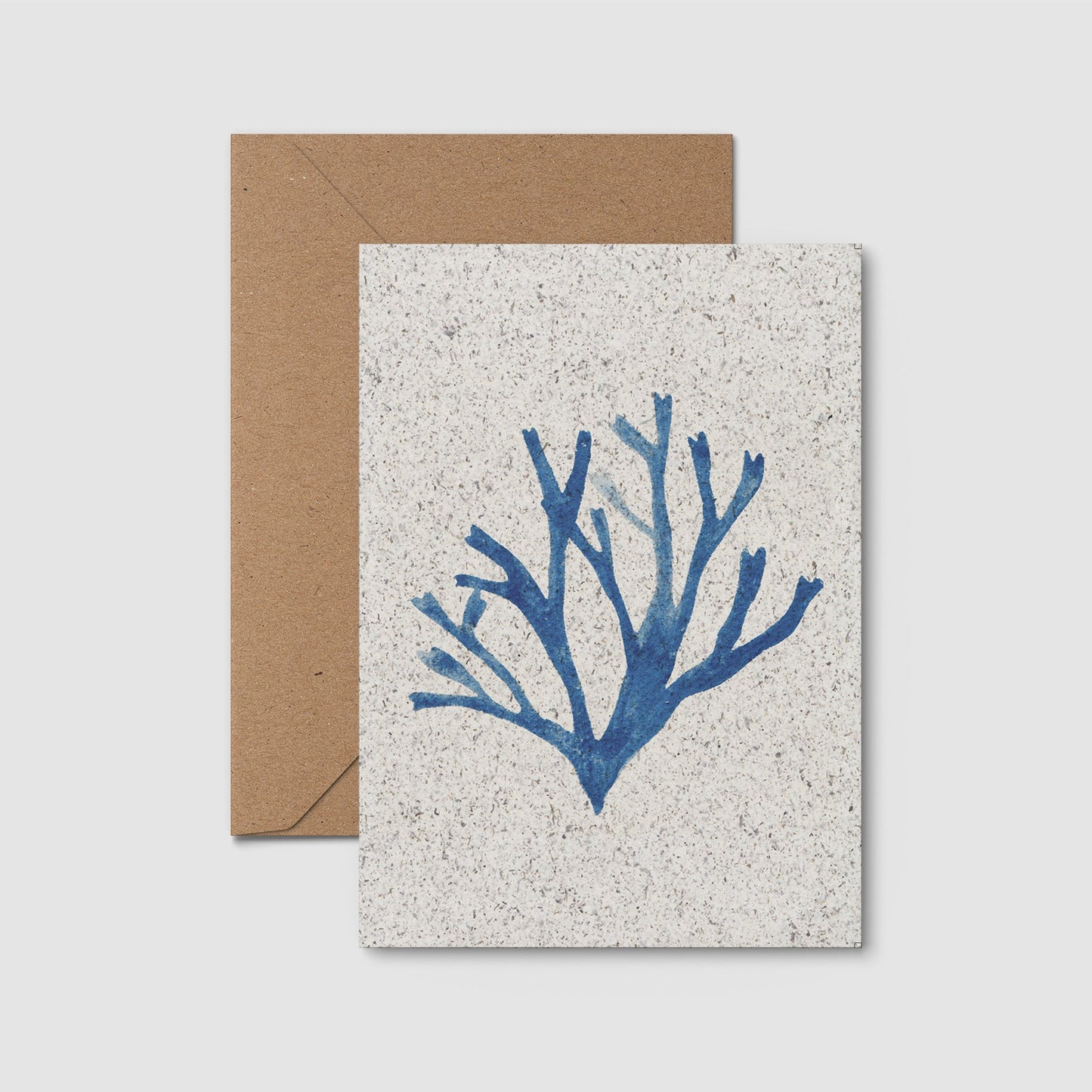 Card with blue seaweed design and brown envelope on a light gray background
