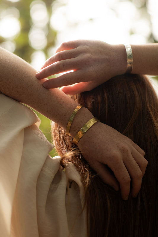 Close-up of hands with bracelets on a blurred natural background