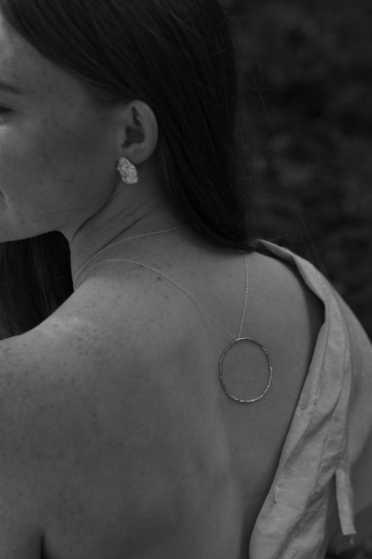 Person wearing a circular earring with a blurred background