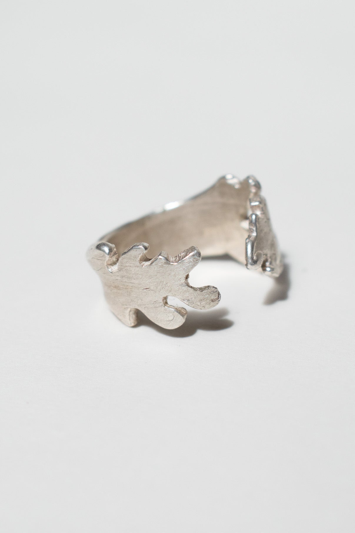 Silver ring with a unique design on a light gray background