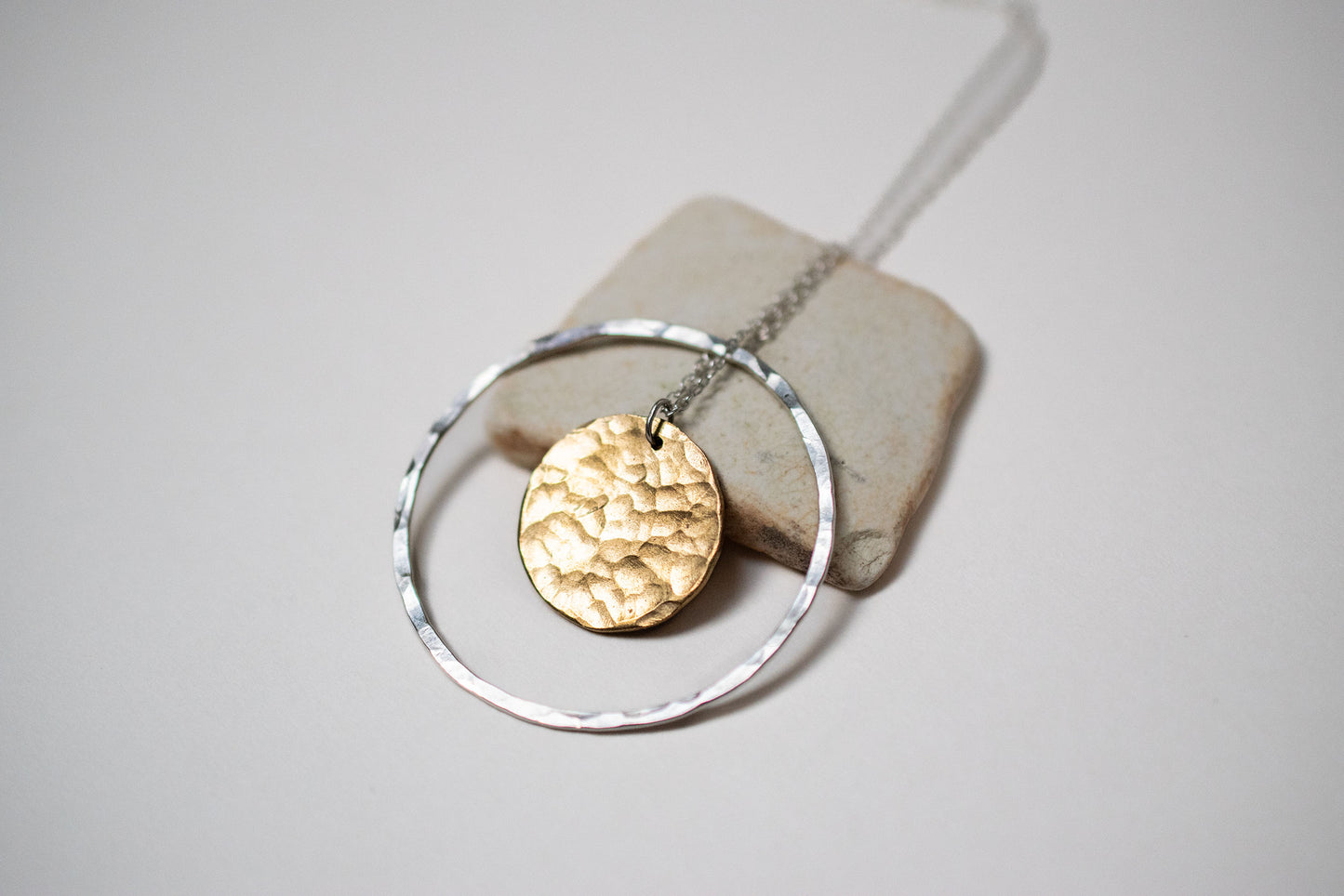 Necklace made from a silver hoop with a brass moon in the centre. 