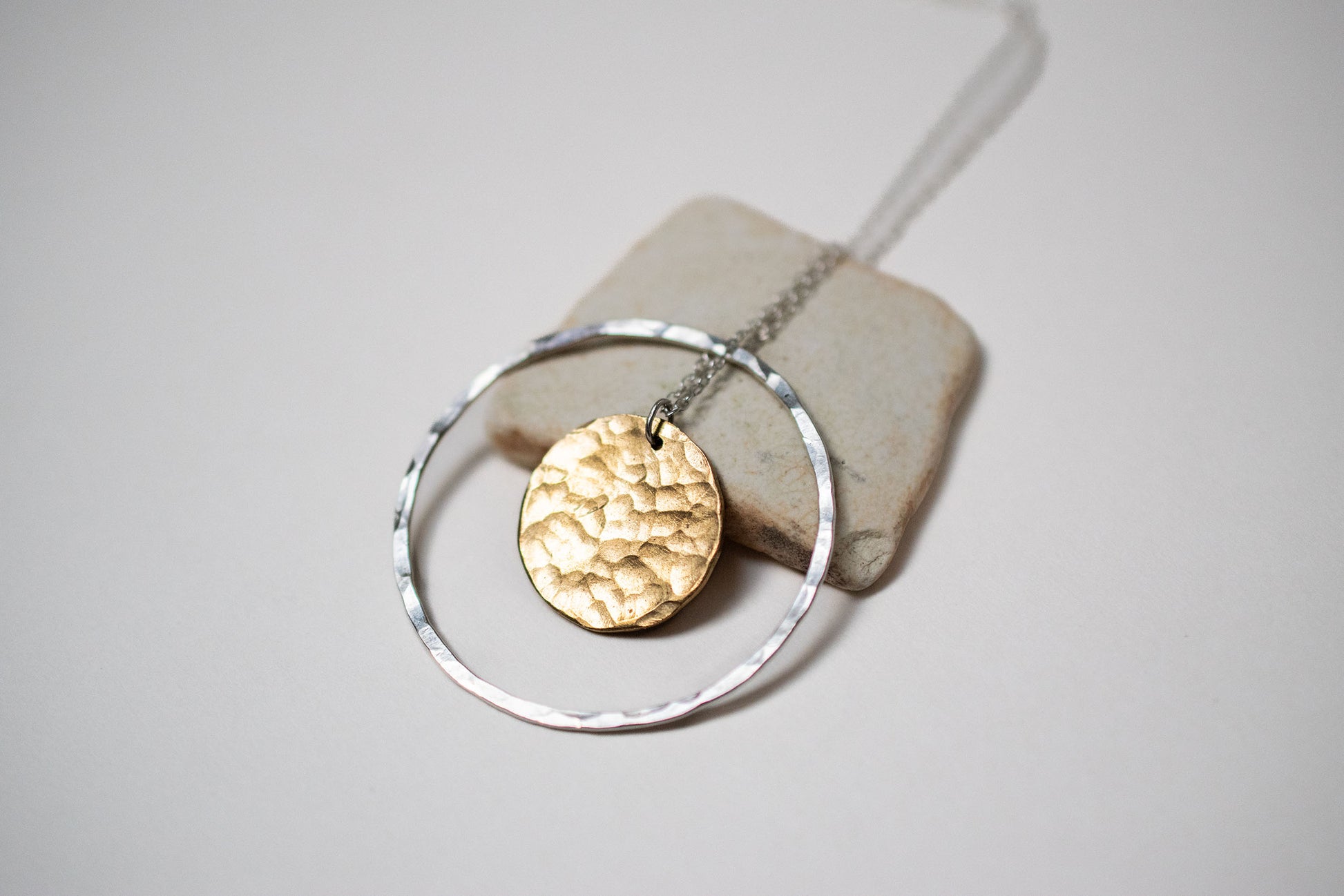 Necklace made from a silver hoop with a brass moon in the centre. 