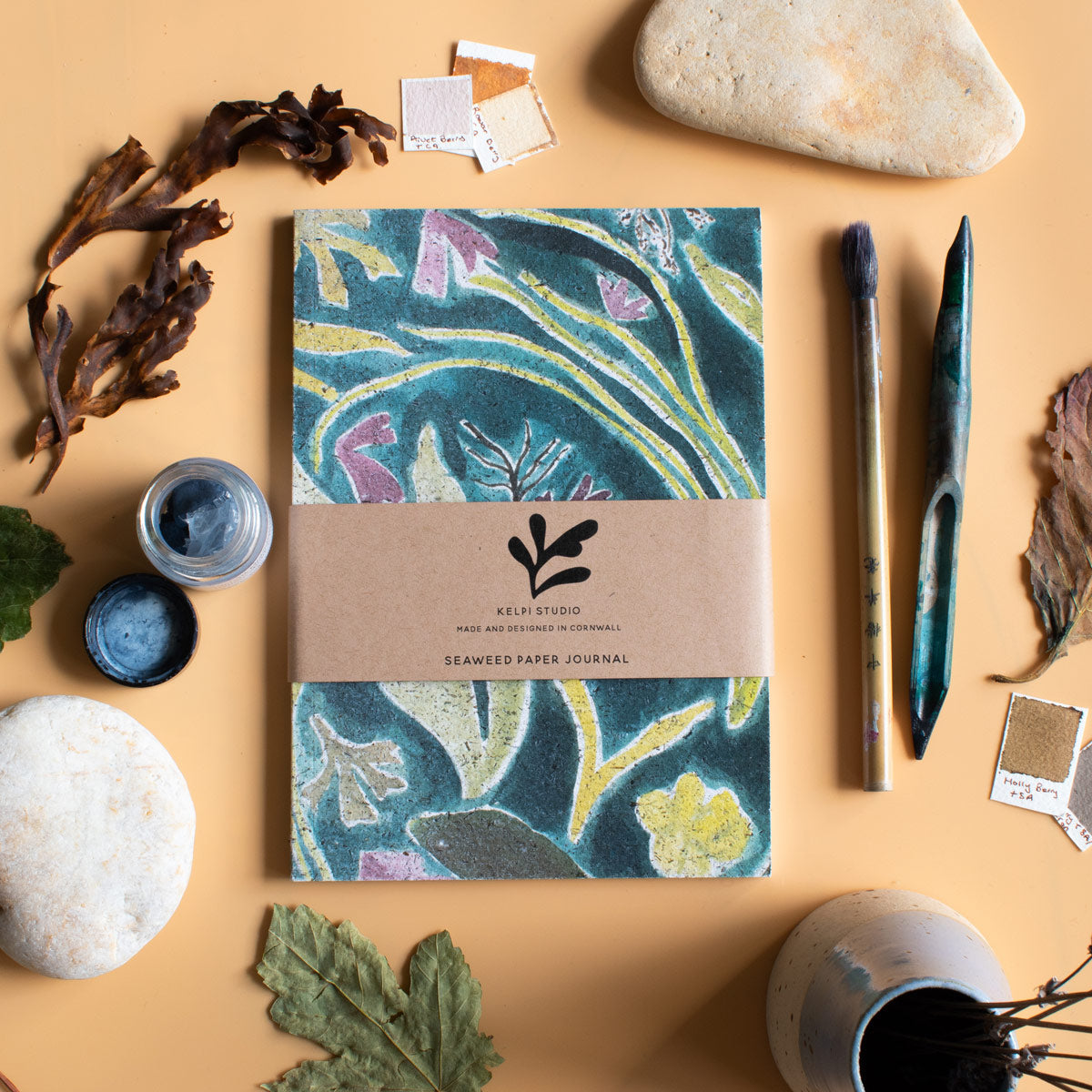 Seaweed journal with a green seaweed design on an artist's table.