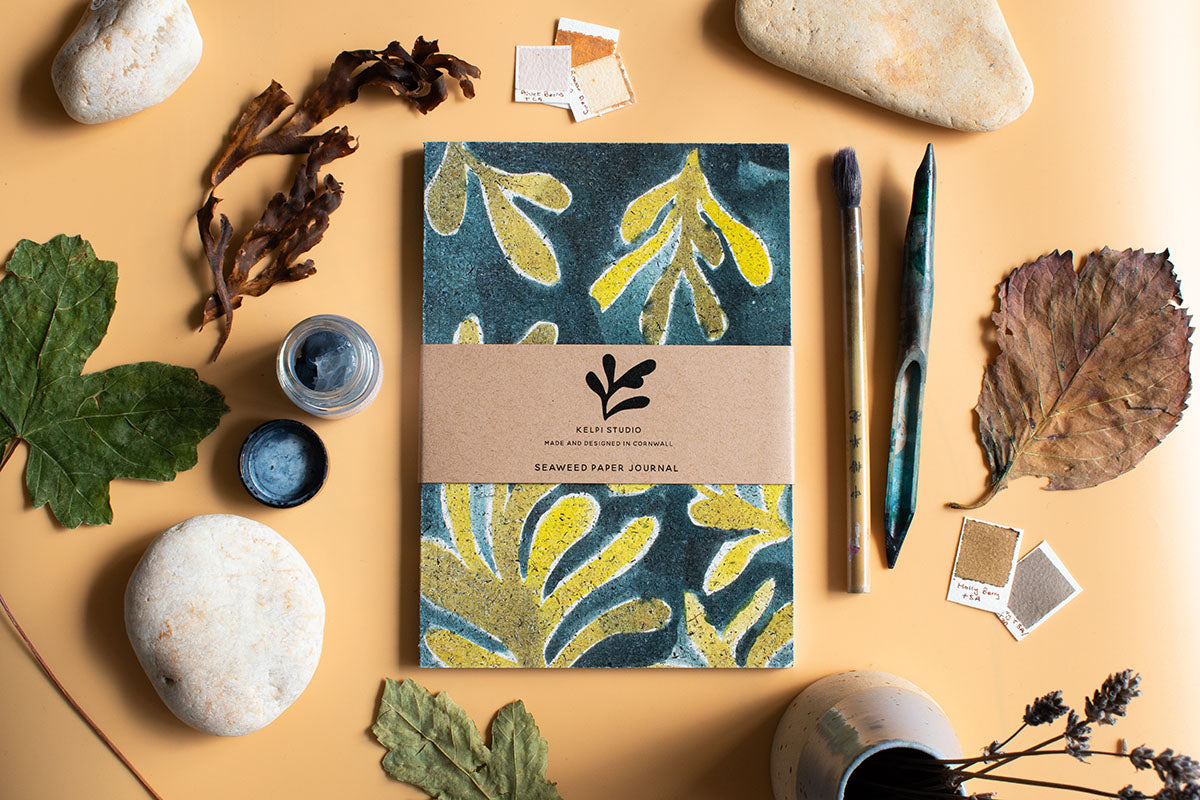 Seaweed journal with a green kelp design on an artist's table