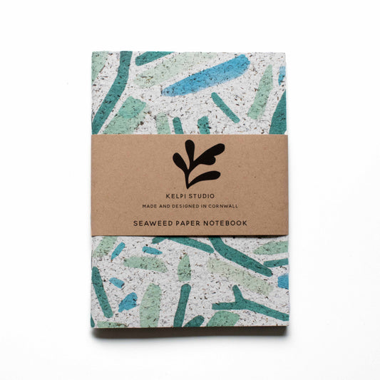 Seaweed notebook with a blue seaweed design on an artist's table