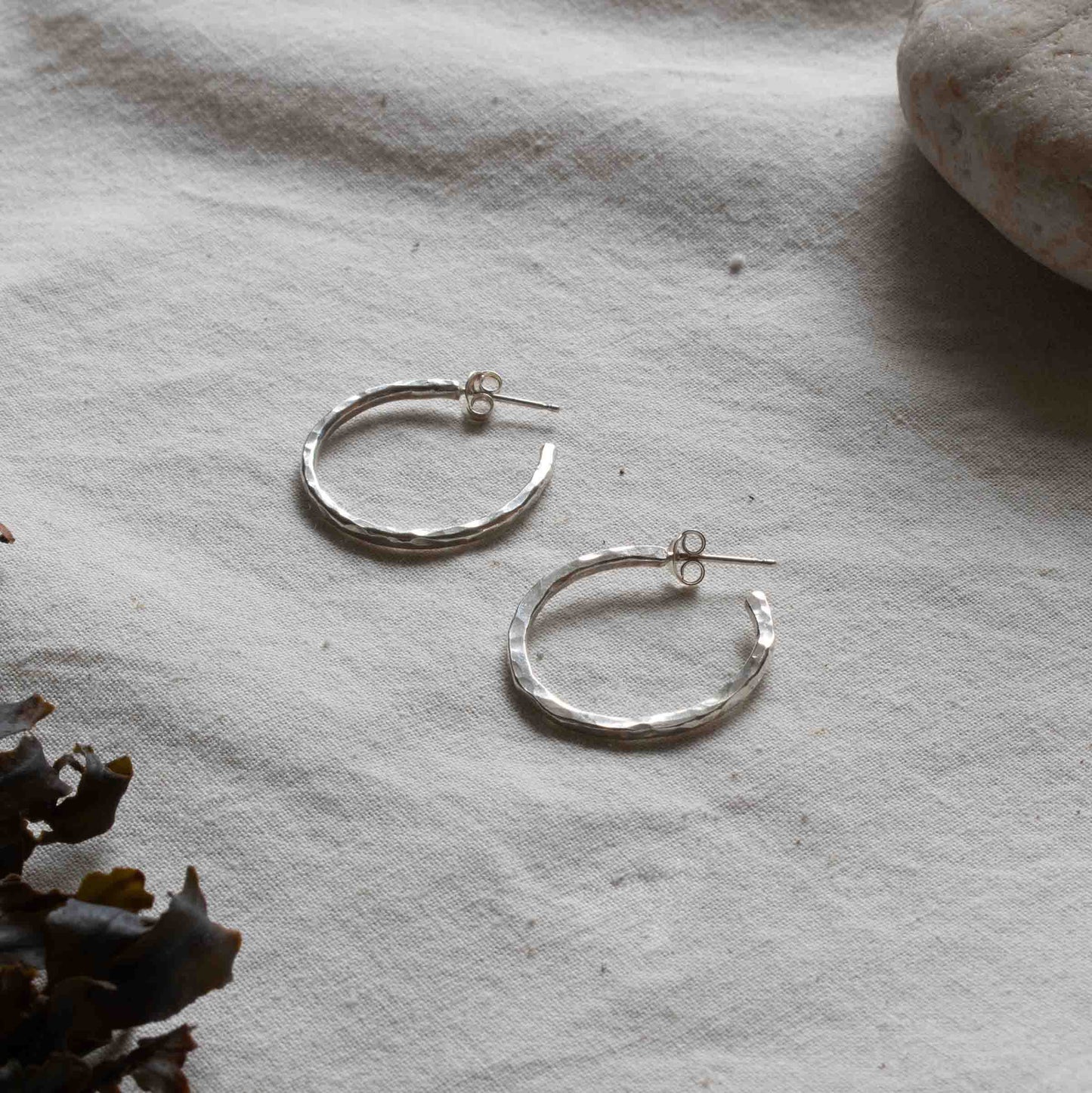 Two silver hooped earrings