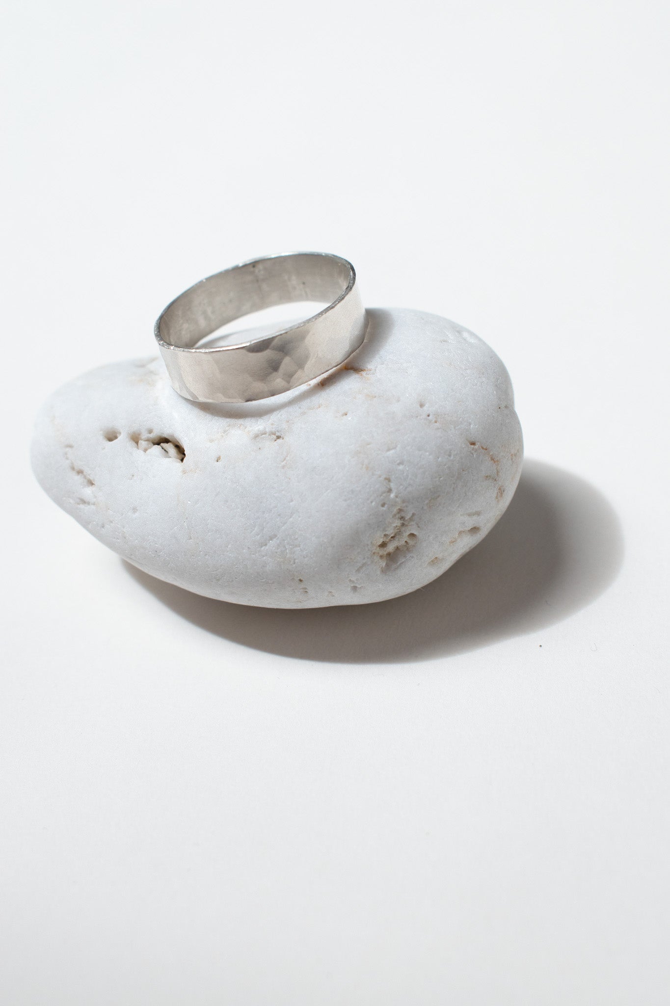 Silver ring on white pebble