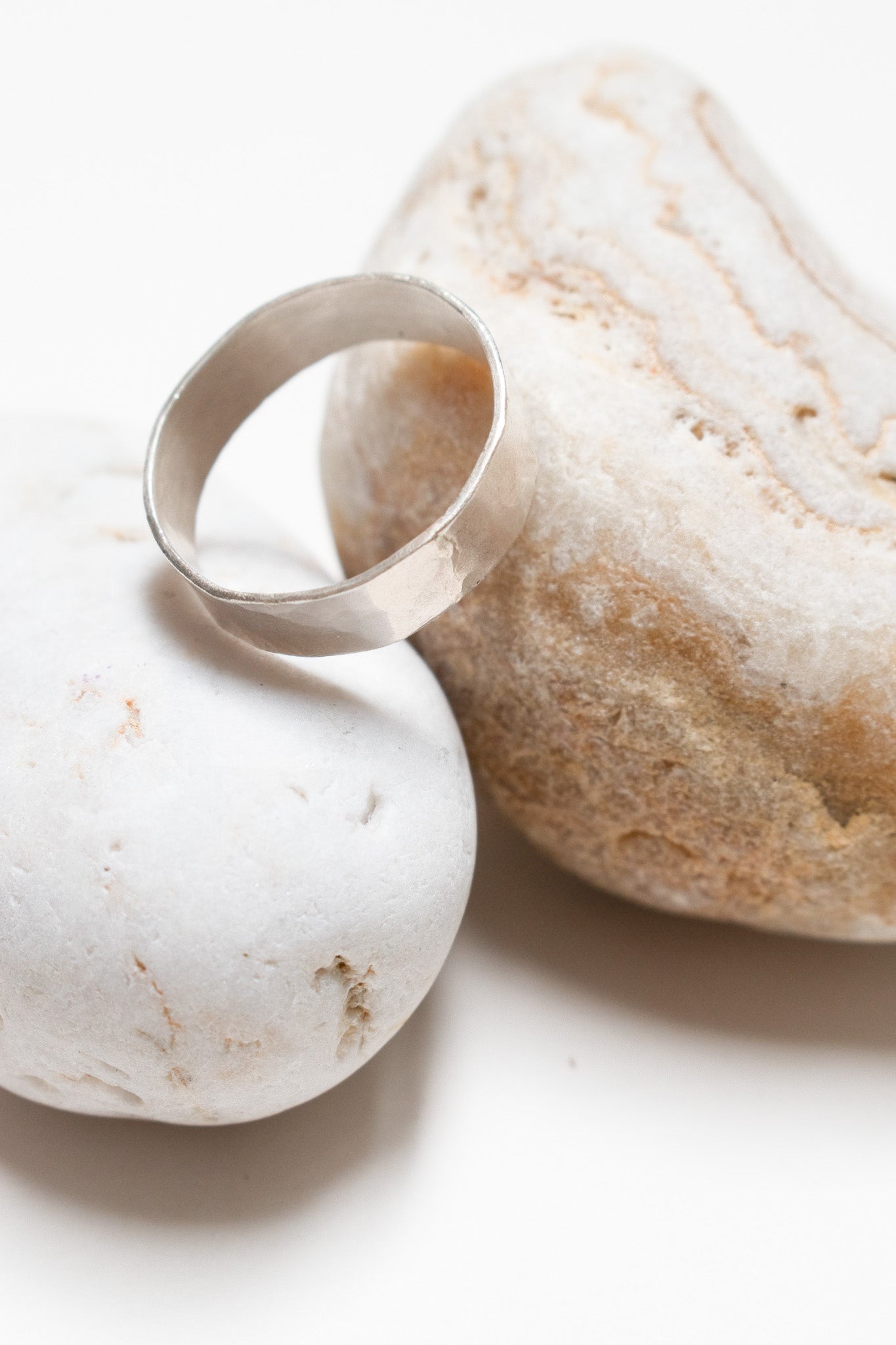 Silver ring on two pebbles