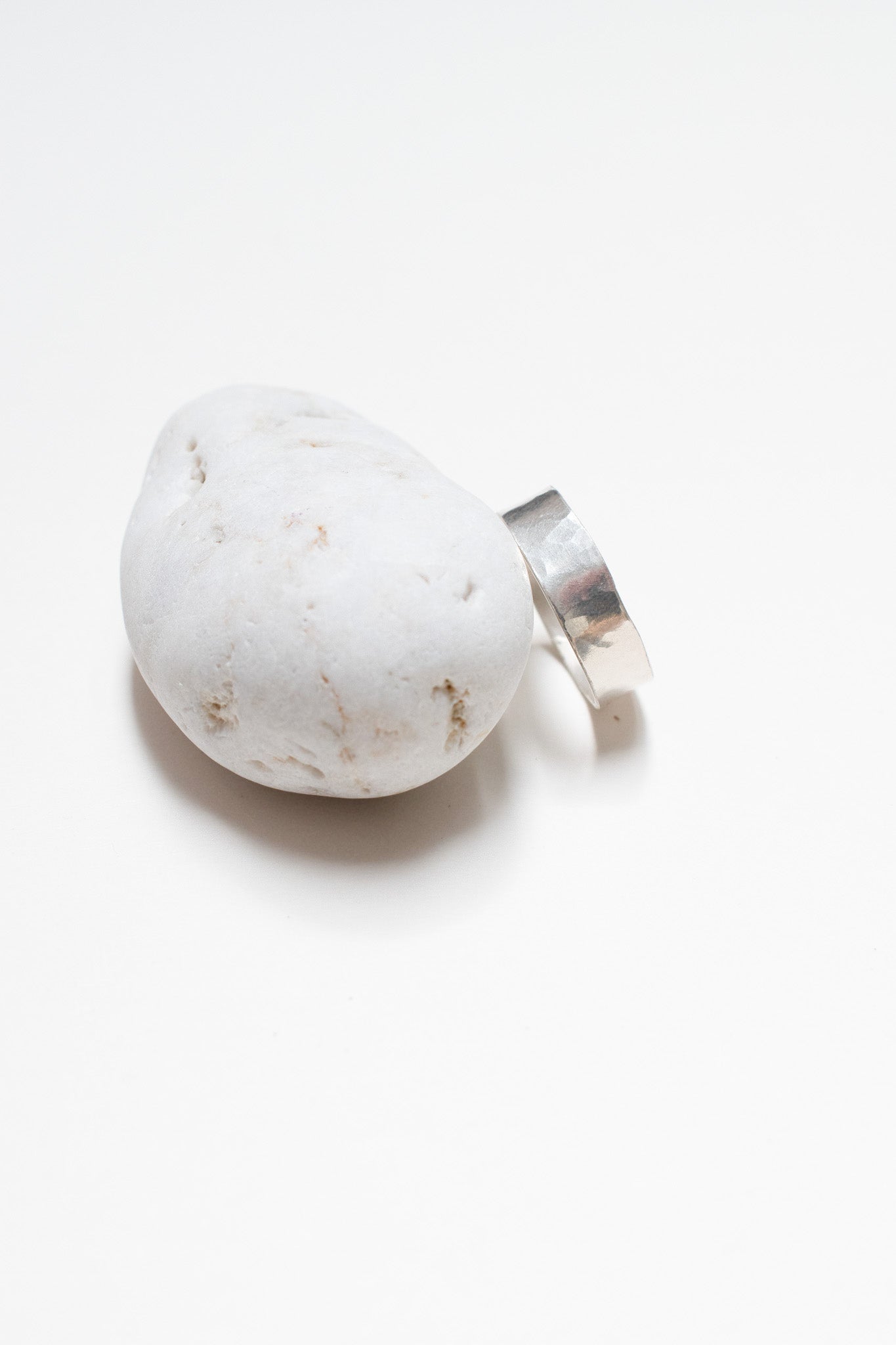 silver ring on white pebble