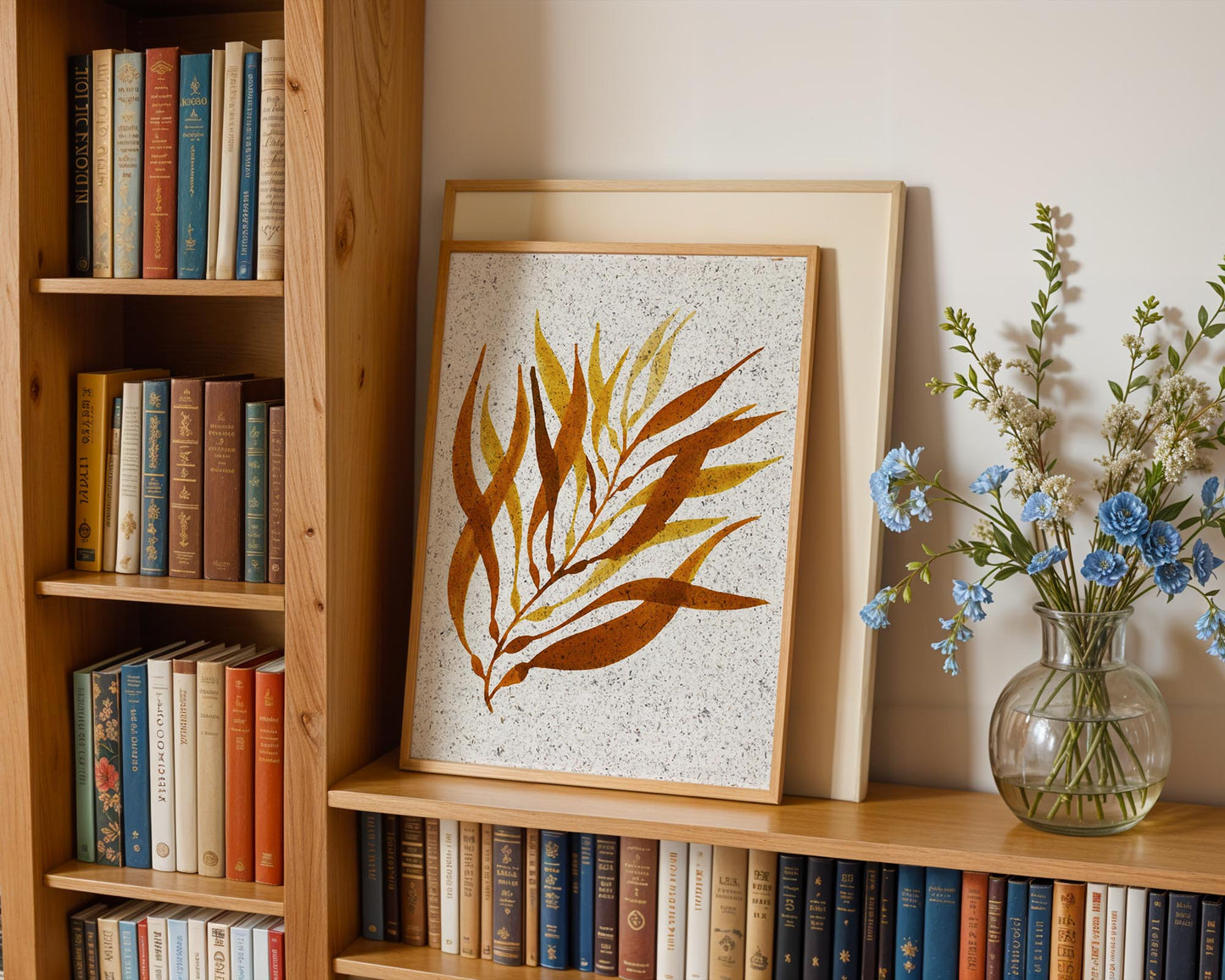 Painted picture of kelp on seaweed paper. The frame is on a bookshelf.