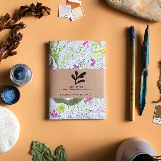Seaweed notebook with a delicate seaweed design on an artist's table