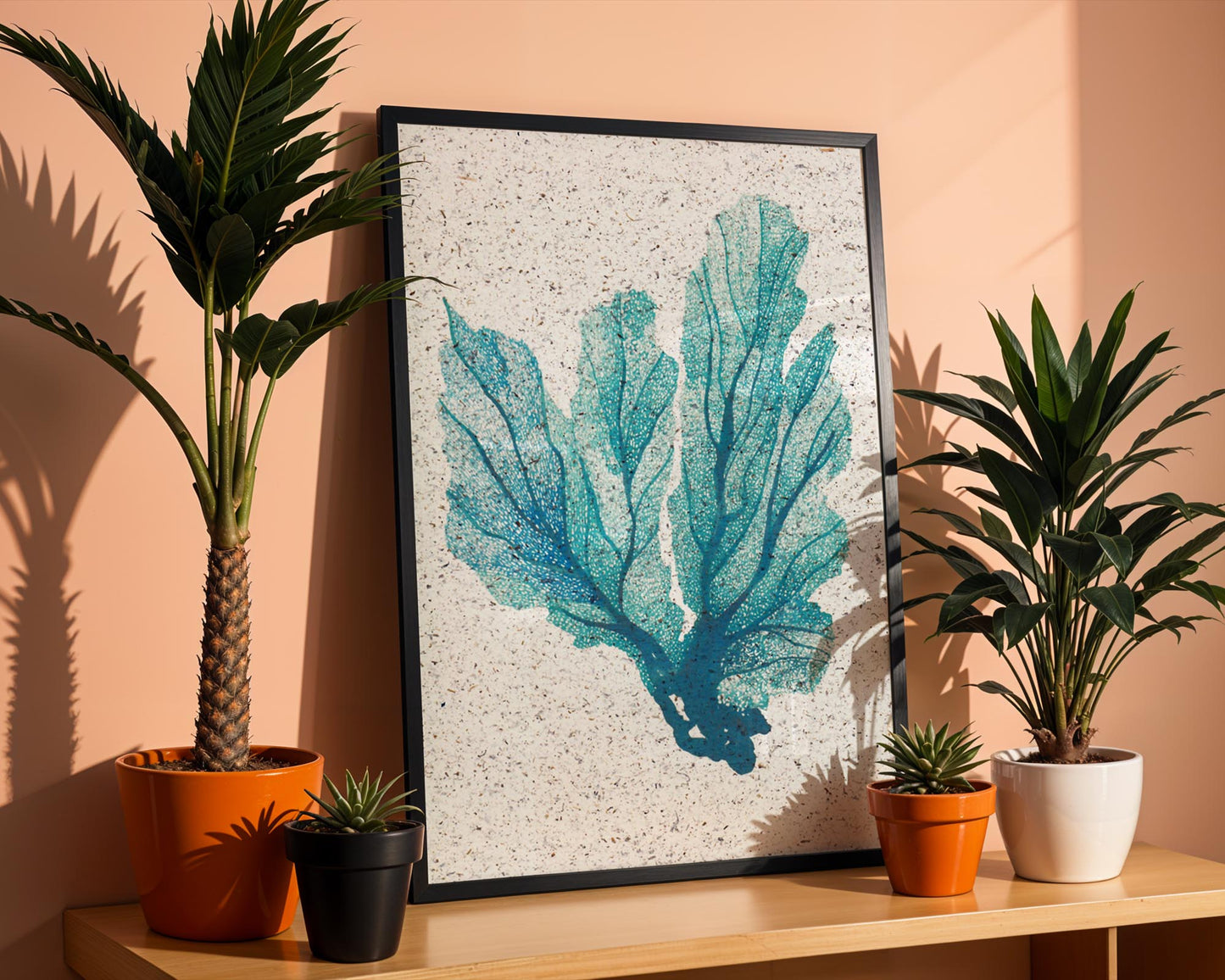 Framed picture of a print of a seafan with plants around it. 
