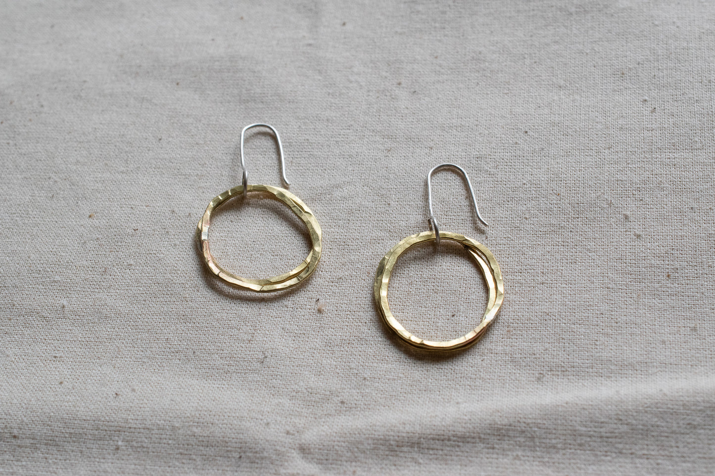 Small brass hooped earrings on canvas