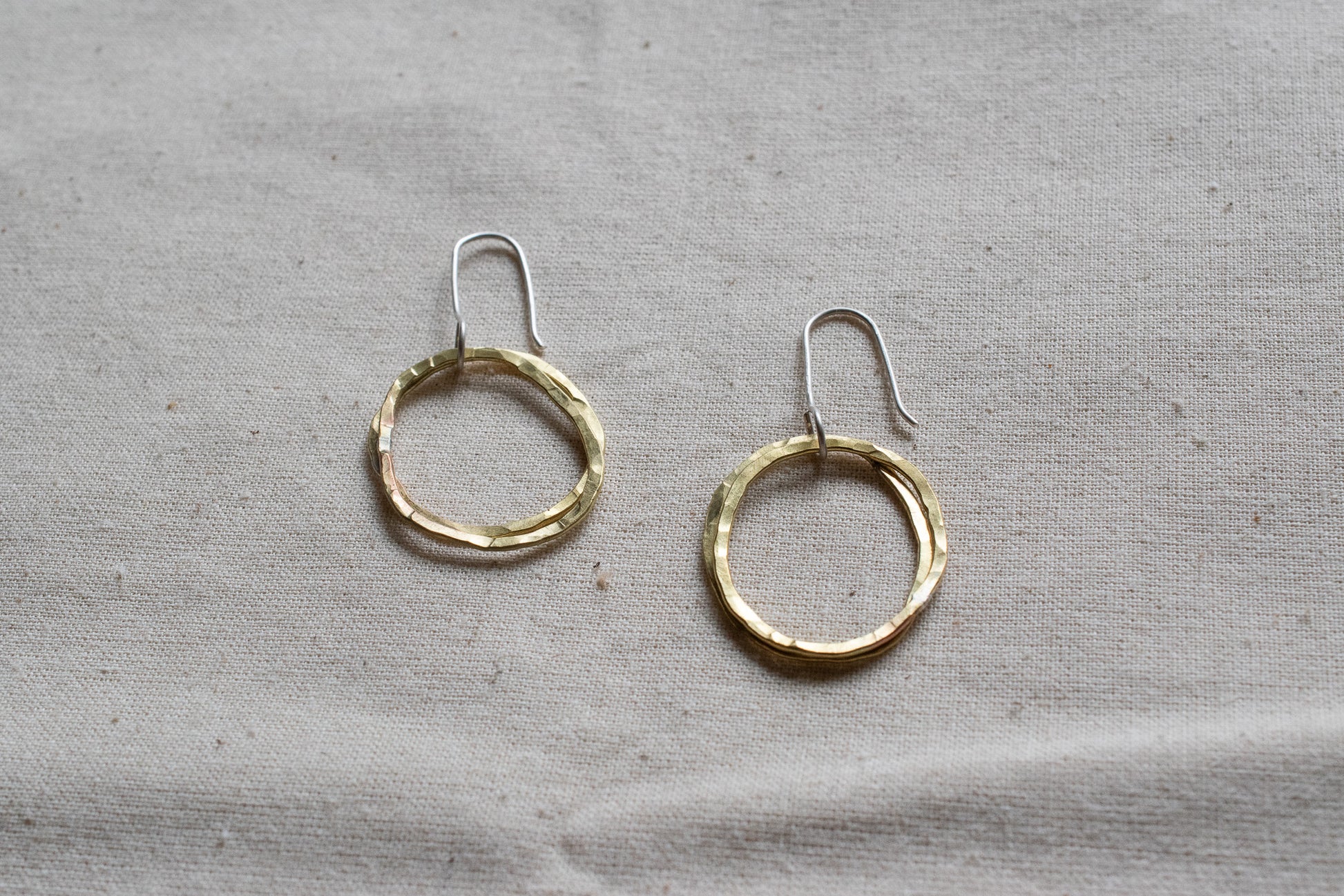 Small brass hooped earrings on canvas