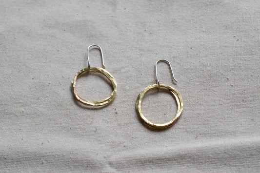 Small brass hooped earrings on canvas